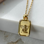 Close-up of Seraphina gold tarot-style pendant with engraved angel and four zirconia stones on a white background