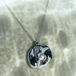 Front-facing view of the silver flower necklace on cream background