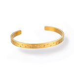 Minimalist celestial bracelet with star engravings and stones, photographed on a white background.