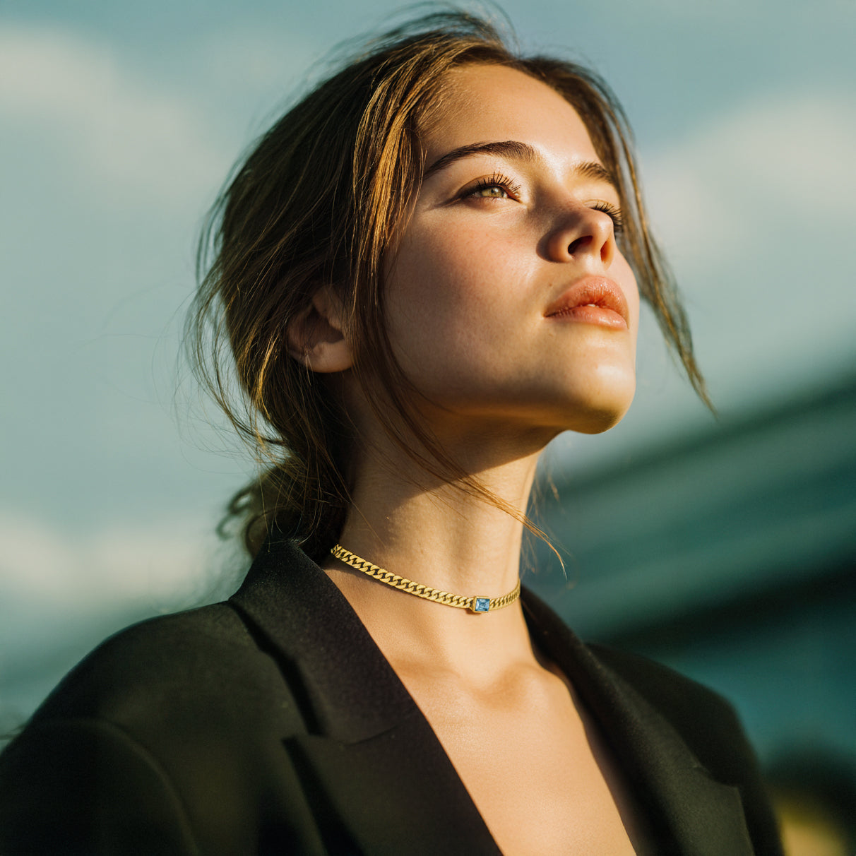 Golden hour portrait of a woman wearing a gold choker necklace from the Fire Collection by Avyrona — glowing light, confident gaze, and warm tones representing the fire element.