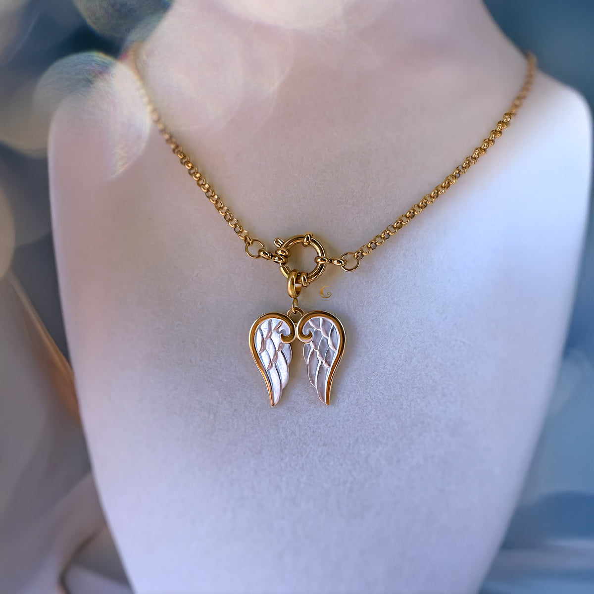 Gold necklace with a heart-shaped pendant on a mannequin bust.