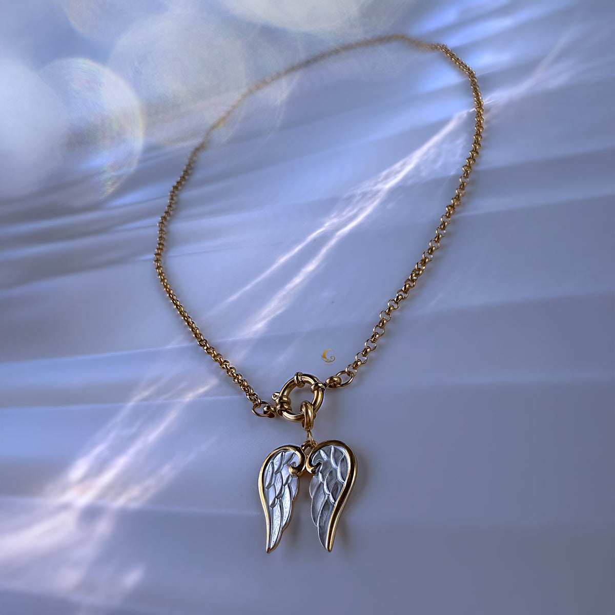 Necklace with angel wing pendant on a soft white background