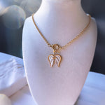 Gold necklace with angel wing pendant on a mannequin bust.