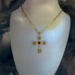 Gold necklace with a cross pendant on a mannequin bust.