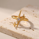 Gold ring with star designs on a textured beige surface