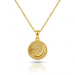 Gold necklace with a round pendant on a white background