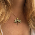 Gold dragonfly necklace on a person with blonde hair