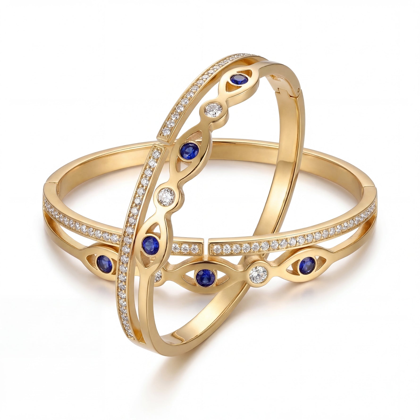 Gold bangles with blue gemstones and clear stones on a white background
