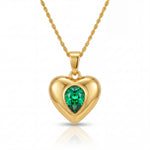 Gold heart-shaped pendant with a green gemstone on a white background