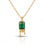 Gold necklace with a green gemstone pendant on a white background