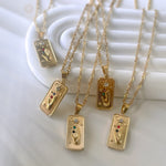Gold necklaces with rectangular pendants on a white background