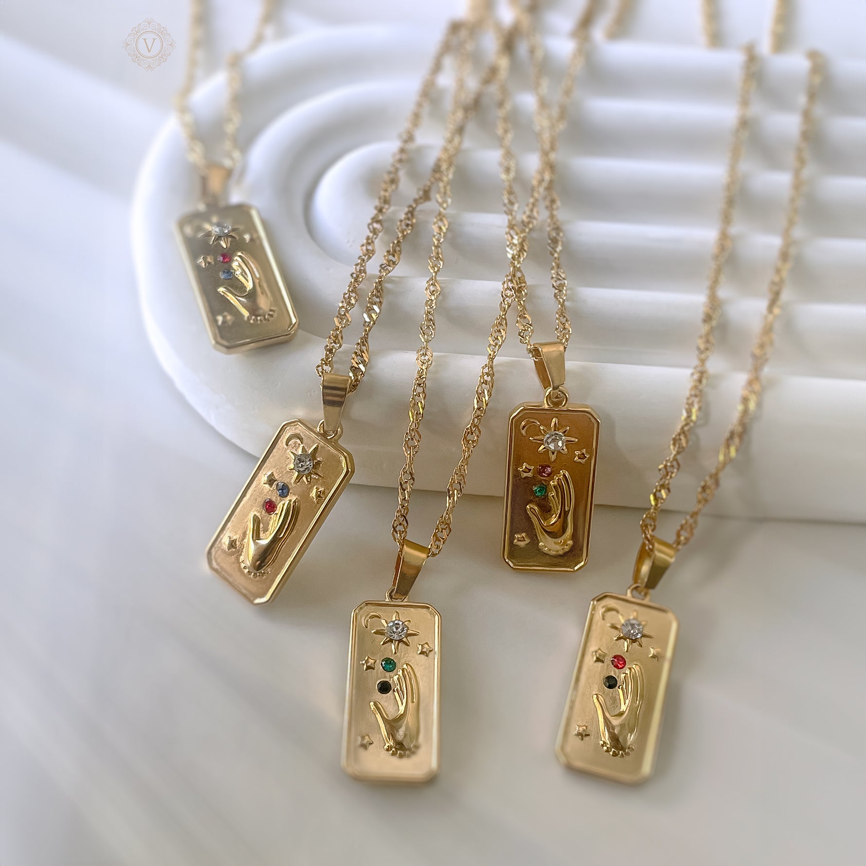 Gold necklaces with rectangular pendants on a white background