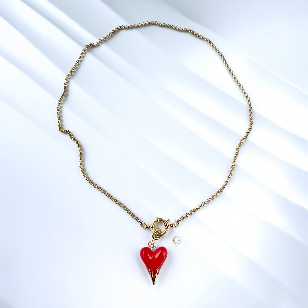 Overhead view of necklace forming a loose circle, highlighting chain texture and pendant