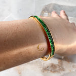 Woman wearing emerald green bangle bracelet – styled on wrist with natural light reflections, strong and confident design