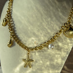 Side view showing Halina’s bold chain and dangling charms, photographed on a curved display