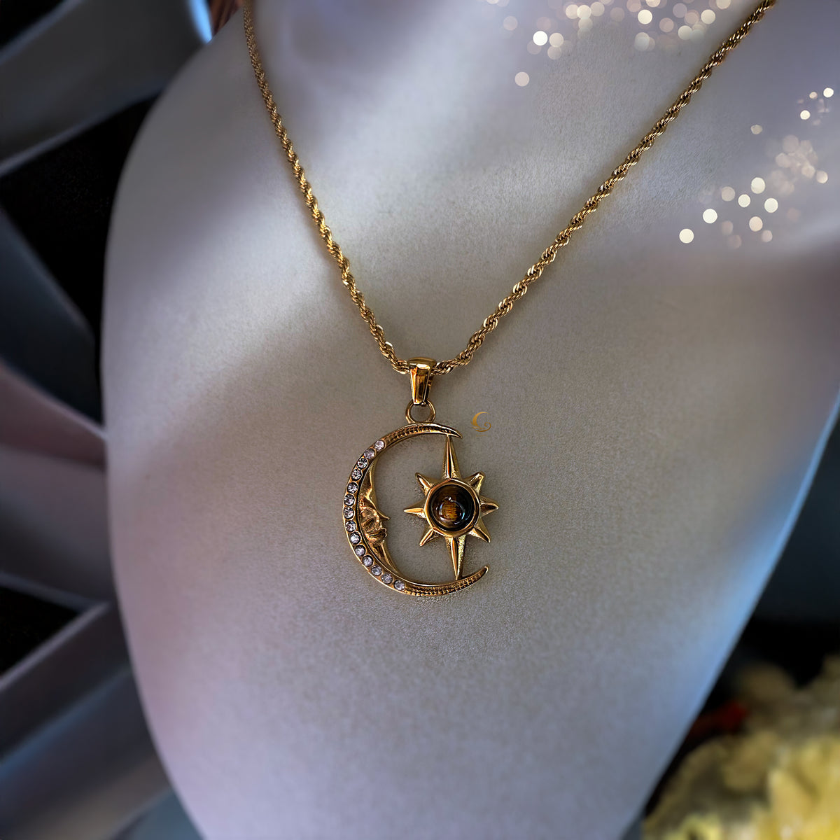 Gold necklace with a moon and star pendant on a mannequin bust.