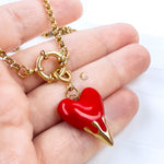 Zayra pendant shown in hand to display scale and intricate flame design