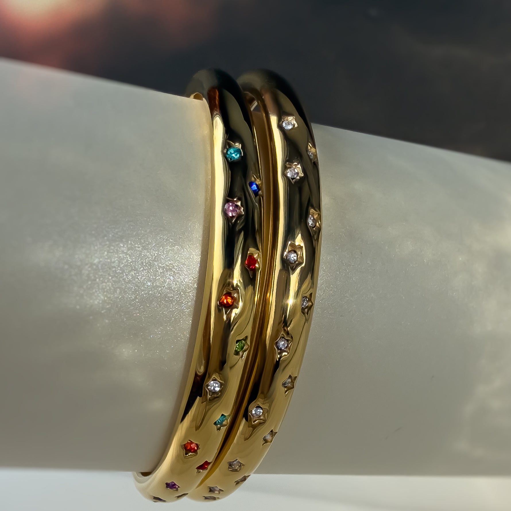 Both Aerina bracelets stacked vertically – one with rainbow zircon stars, the other with clear stones.