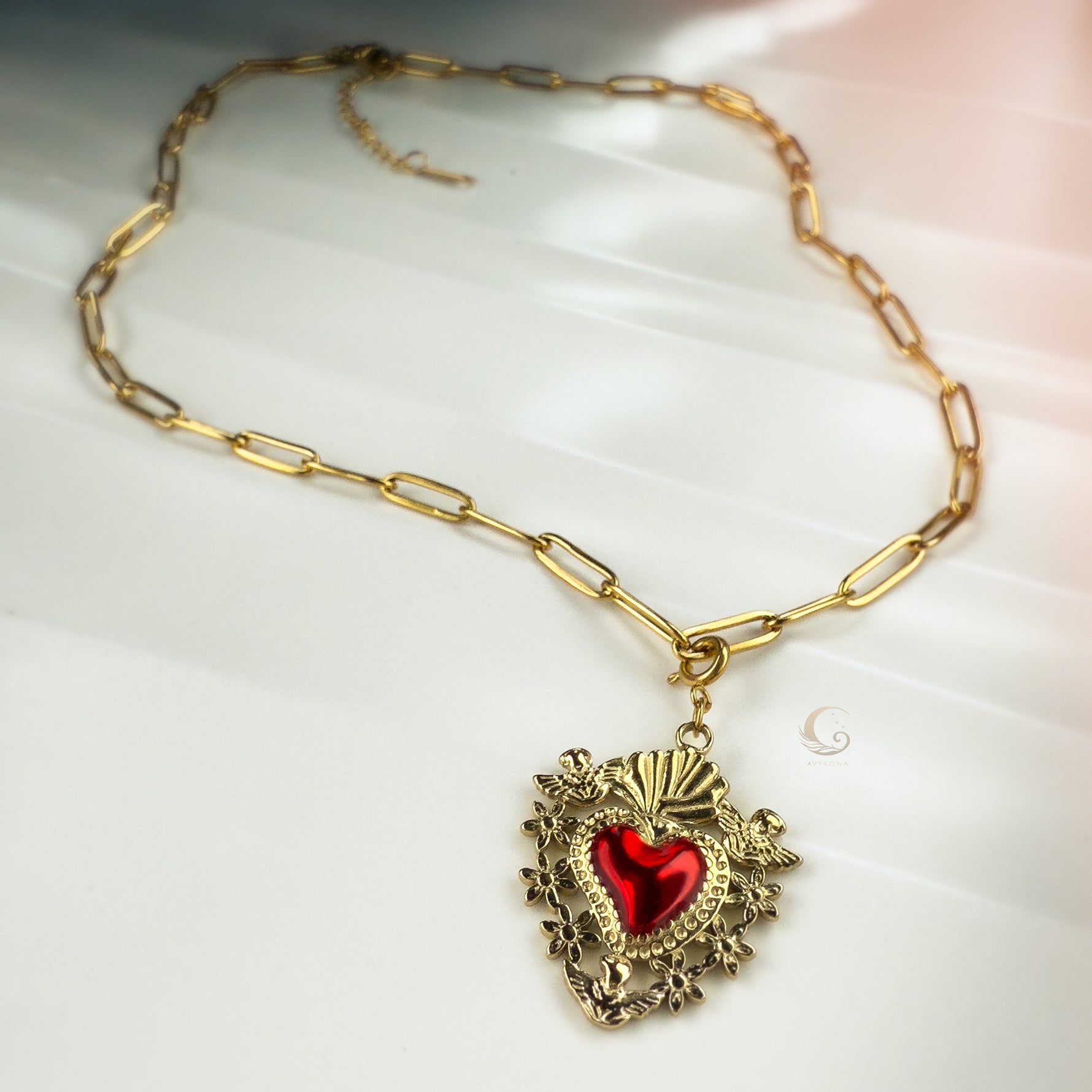 Flat lay of full Amara necklace with paperclip chain and intricate Sacred Heart pendant.