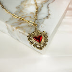  Amara necklace resting on soft marble, showcasing delicate paperclip chain and symbolic pendant.