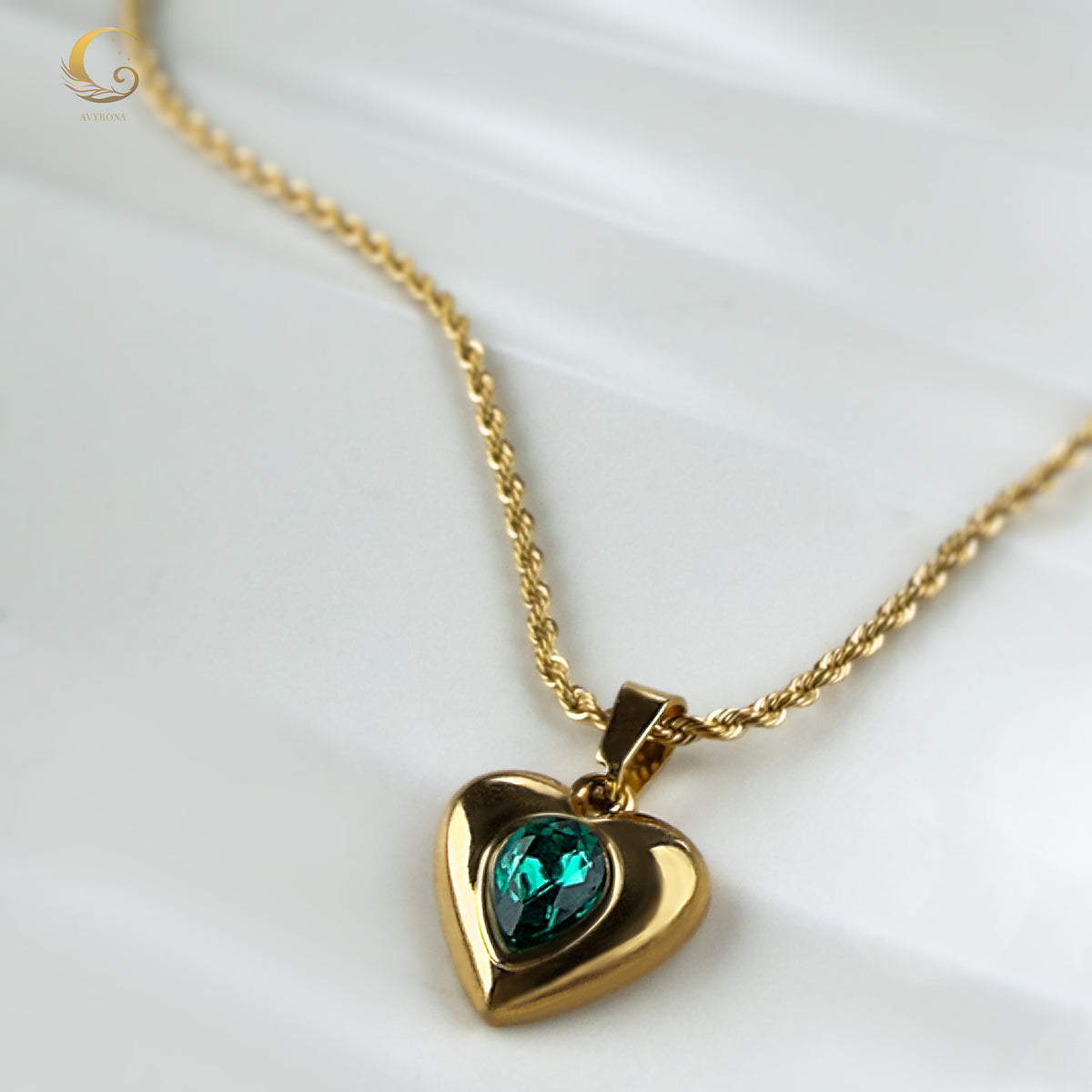Single twisted chain necklace with a glowing green heart pendant on a soft background