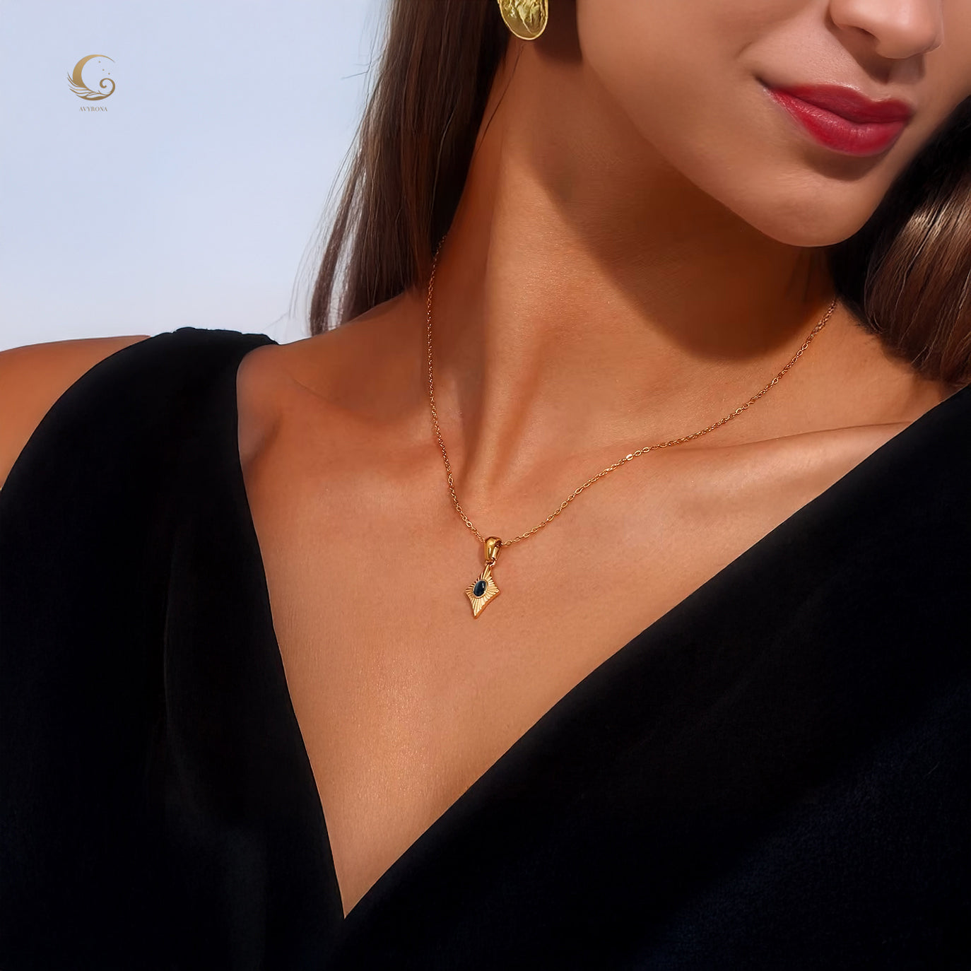 Close-up of Avyrona model wearing black cat eye necklace with gold chain and black outfit
