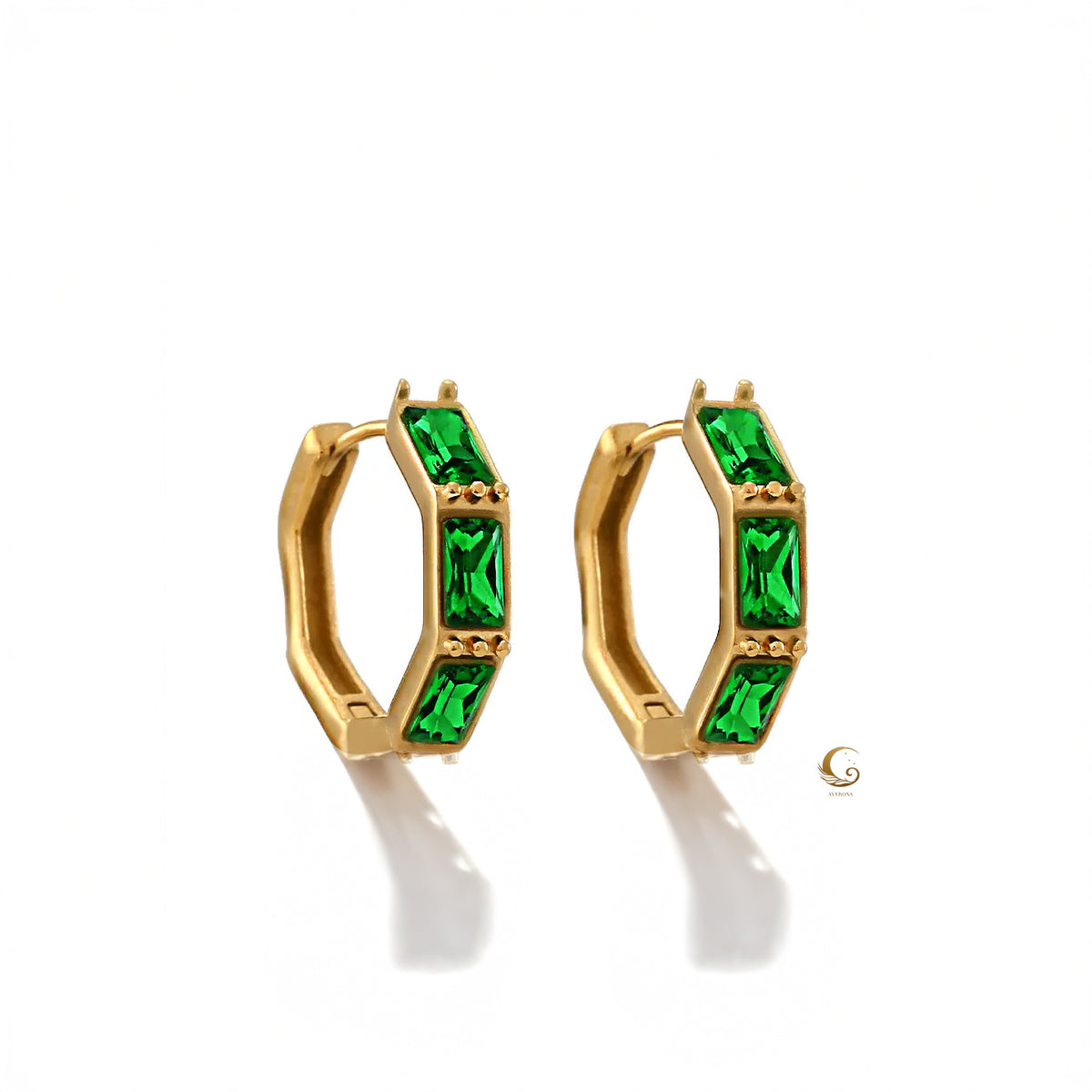 Close-up of Camila hoop earrings with radiant emerald green cubic zirconia stones set in gold-plated hexagonal frames