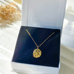 Gold celestial medallion necklace presented in white gift box with navy velvet insert