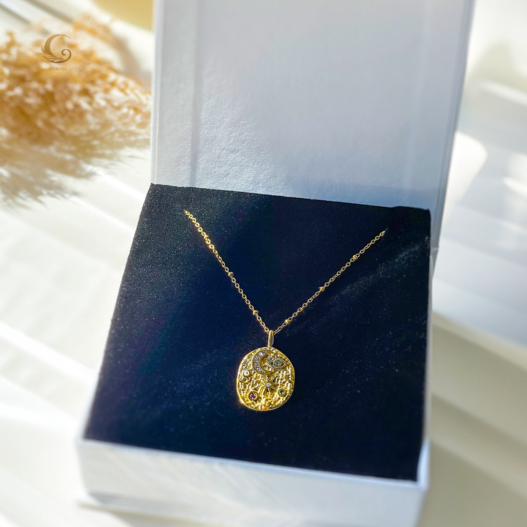 Gold celestial medallion necklace presented in white gift box with navy velvet insert