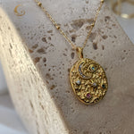 Moon and star medallion necklace photographed from above on marble-like stone block