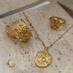 Elara celestial necklace displayed with matching ring and cuff from the same jewelry collection