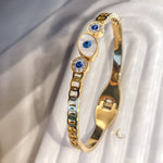 Detailed view of Evil Eye symbol and crystal setting on gold bracelet
