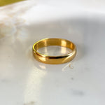 Medium-width 4mm gold ring band on a clean light background.