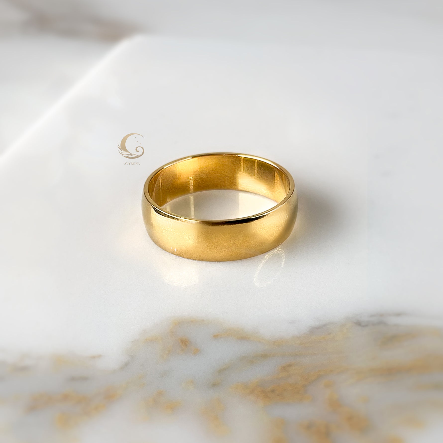 Thick 6mm gold ring band shown flat on soft beige surface.
