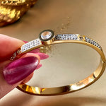 Close-up side angle of the gold bracelet, highlighting crystal-encrusted surface and central round zirconia stone.