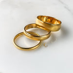 Group of three gold rings overlapping, showing varying thicknesses.