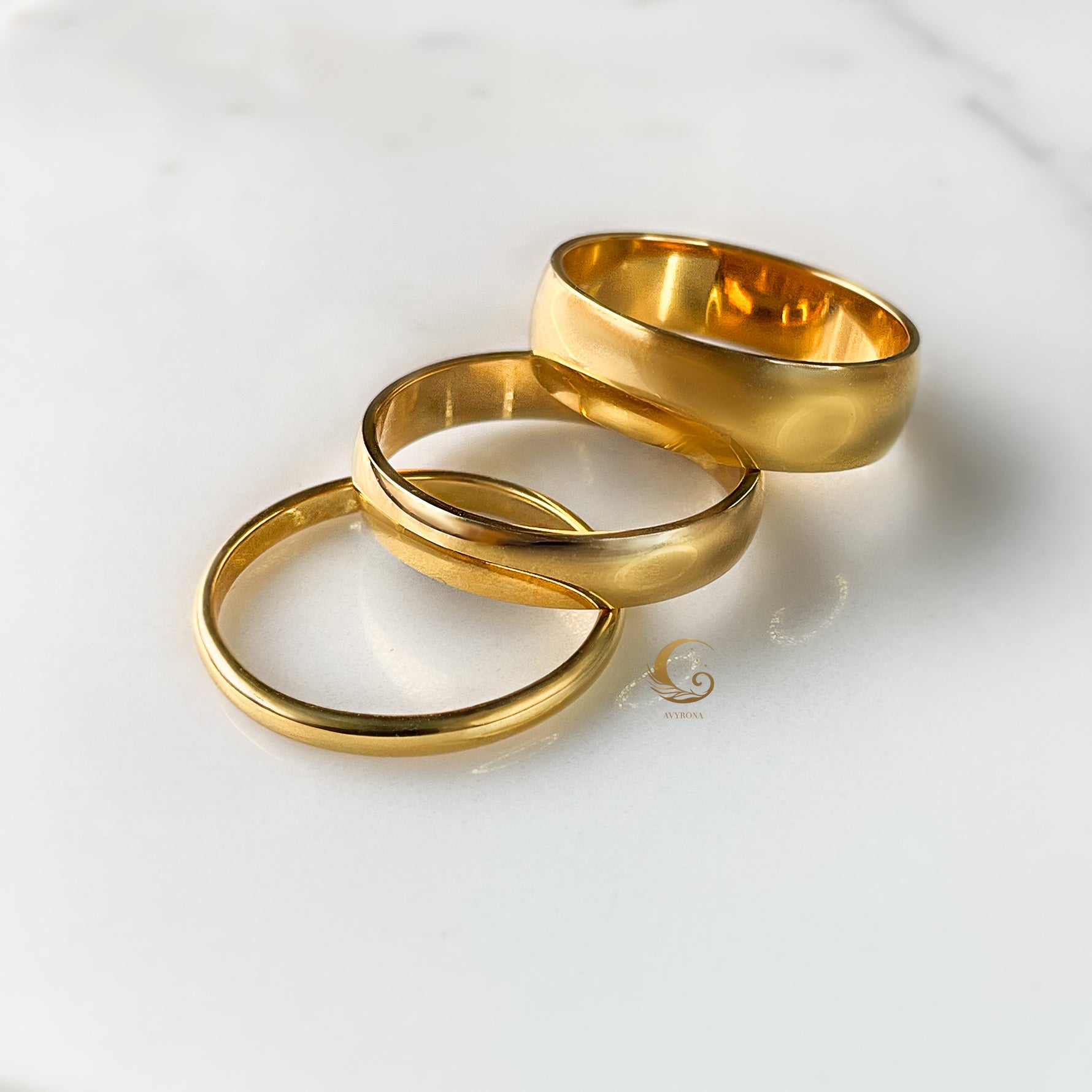 Group of three gold rings overlapping, showing varying thicknesses.
