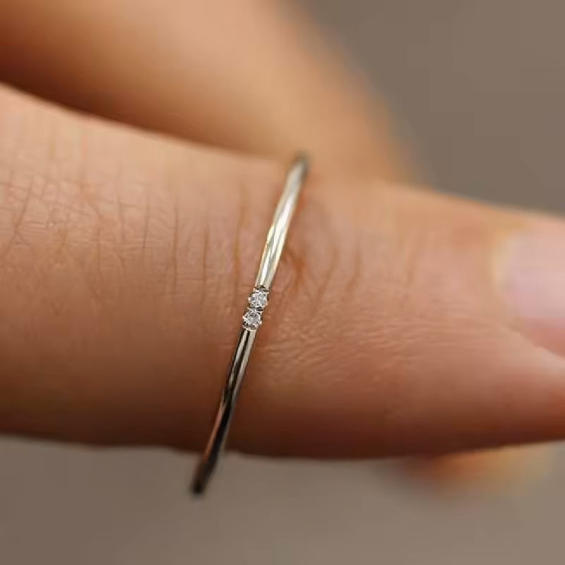 Thin gold zircon ring with one stone, worn on finger