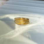 Close-up of multiple gold rings with zircon stones stacked in a round formation