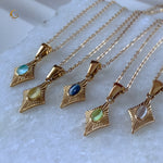 Five Guardian Amulet necklaces arranged in a row, showcasing different gemstone colors including green cat eye in the center.
