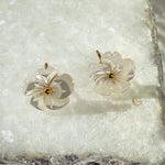 Imira flower earrings photographed on textured marble, highlighting layered petals and gold detail