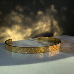 Side view of the Lunara bracelet showcasing detailed celestial engravings and sparkling stones.