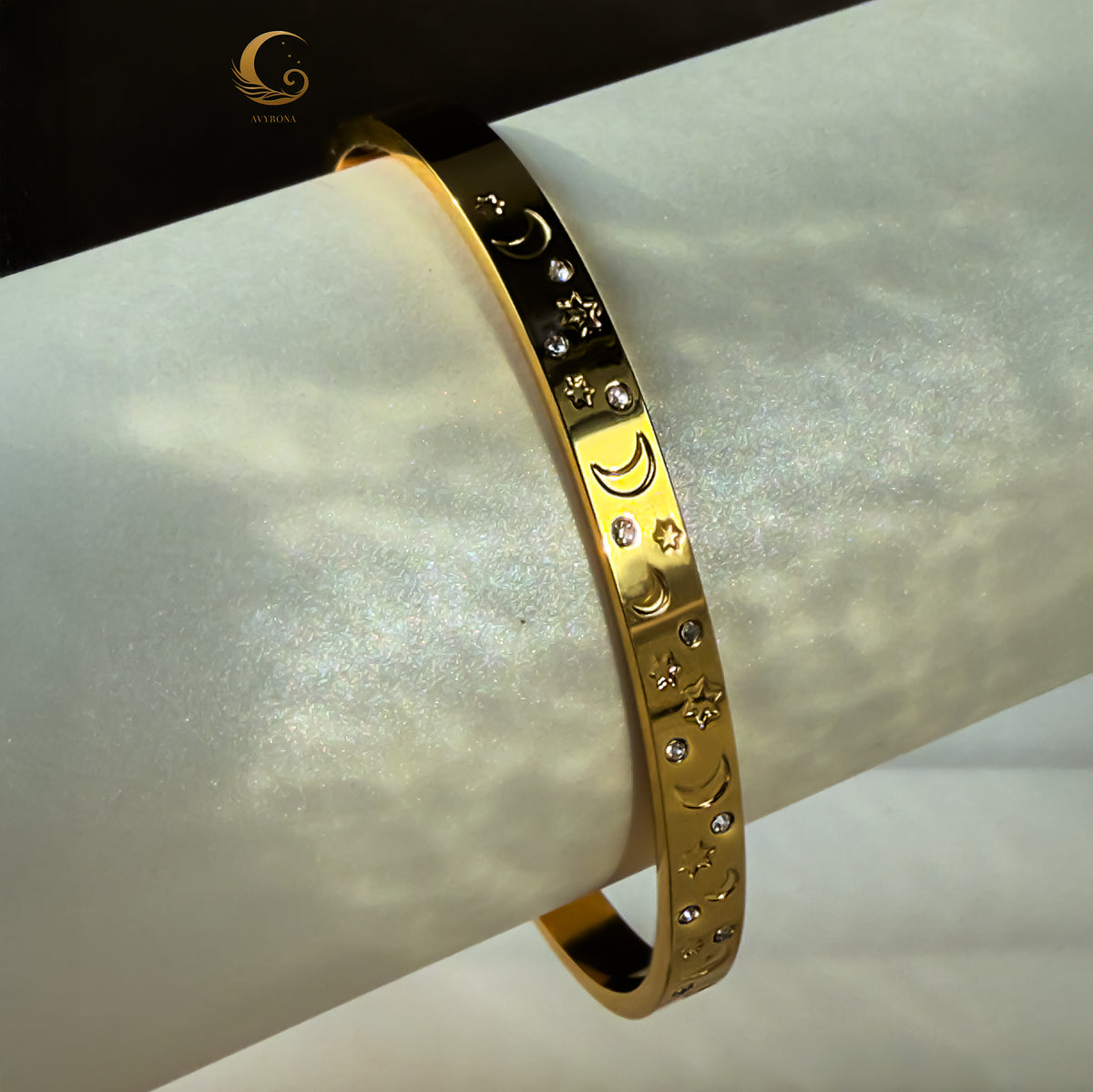 Elegant close-up of Lunara bracelet on white display roll, highlighting crescent moons and starry pattern.