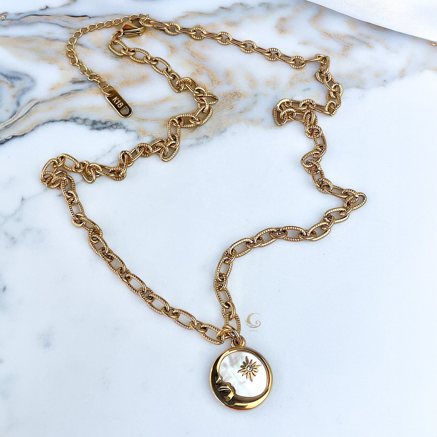  Full Lyra necklace with puffed mariner chain laid out on marble surface.