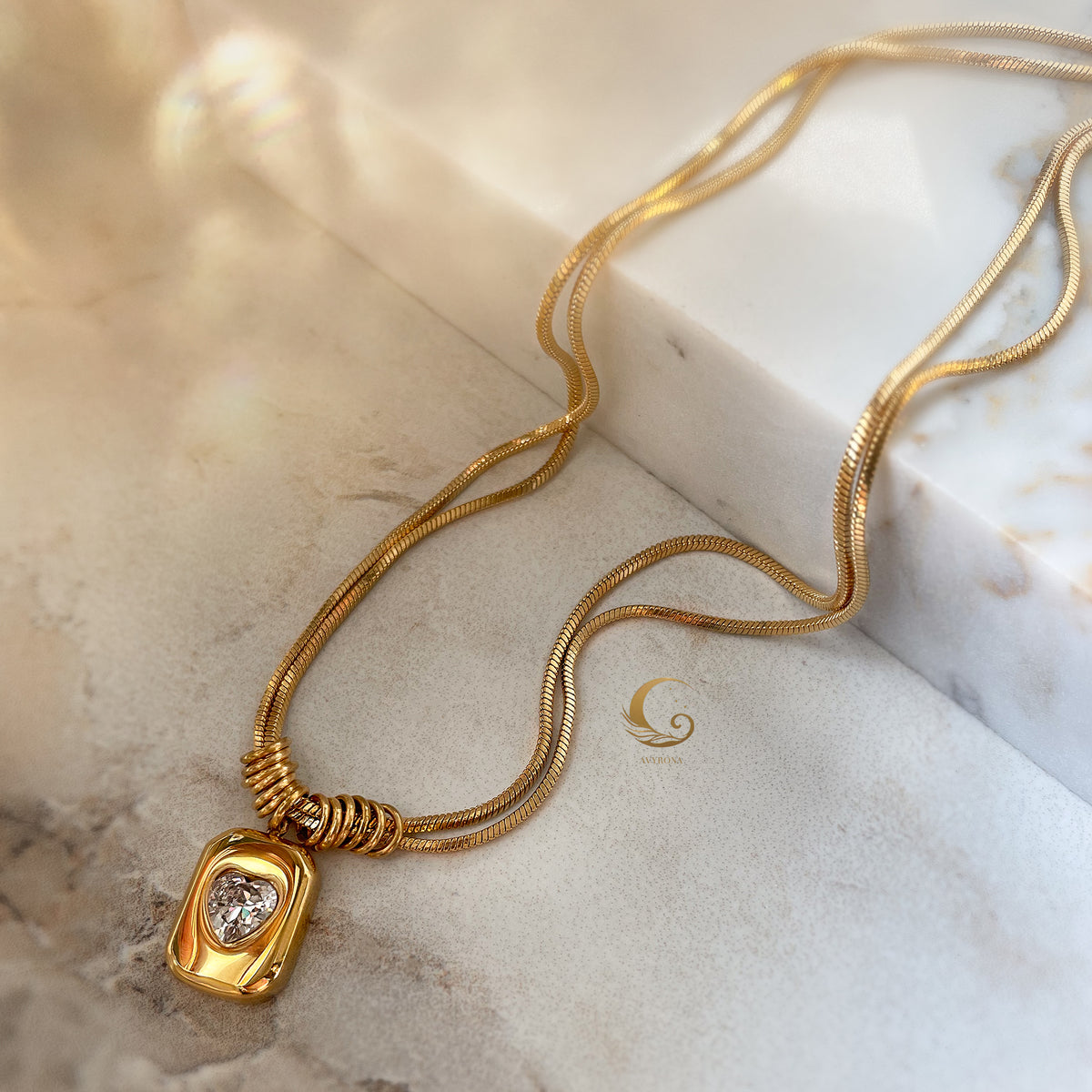  Full view of double snake chain necklace with pendant styled on soft beige background.