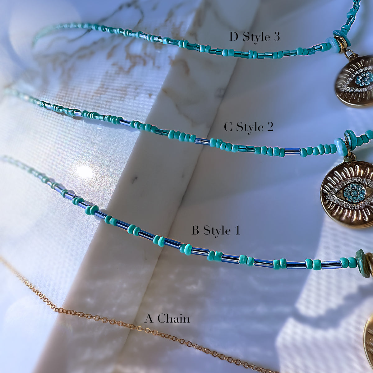 Three necklaces with different styles on a textured white surface