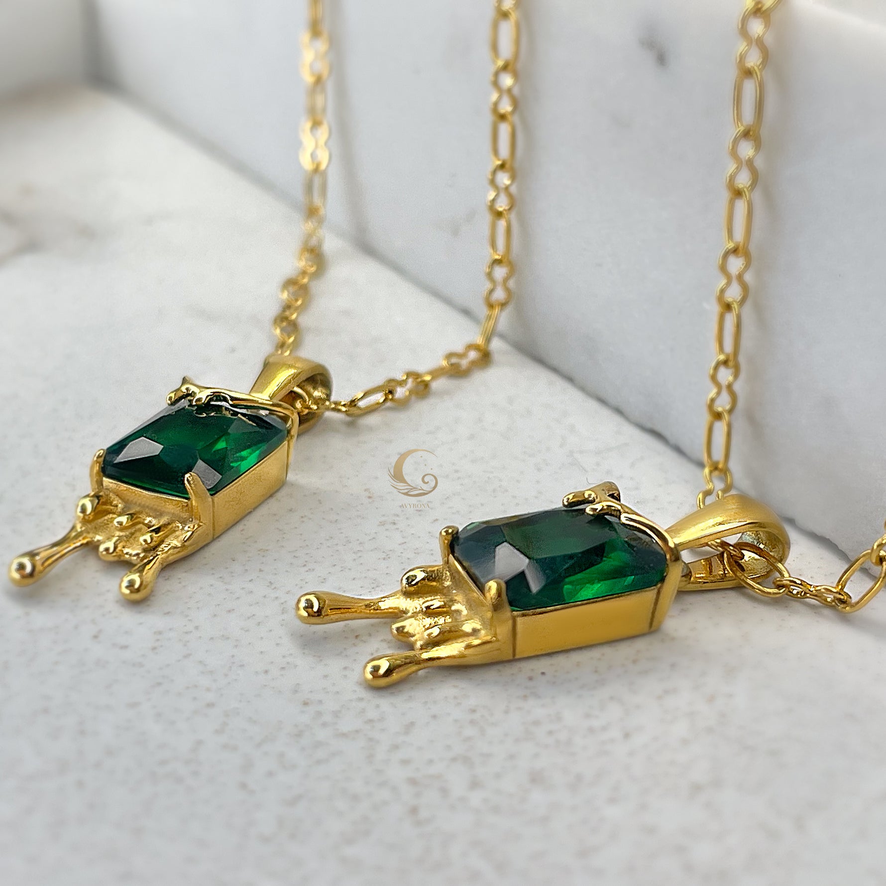 Side-angle view of Mila earthy necklace, highlighting vibrant emerald crystal and golden honey drip details.