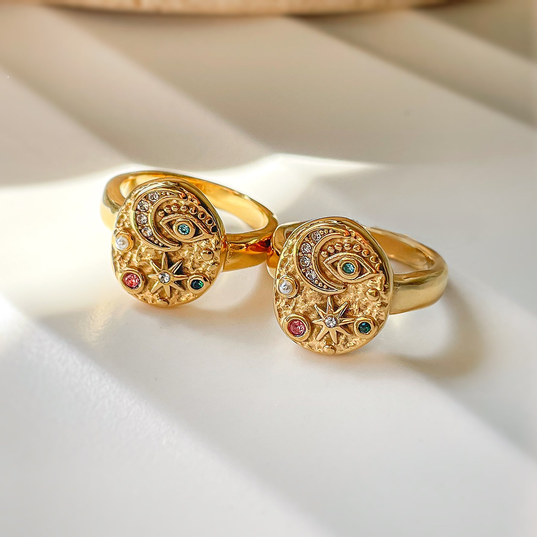 Gold Moonlight ring with celestial motifs including crescent moon, evil eye, and colorful zirconia. Symbolic jewelry in warm sunlight, perfect for gifting. Waterproof, gold-plated stainless steel.