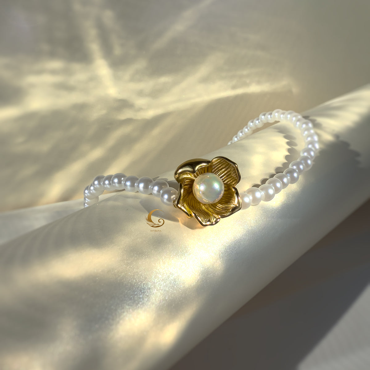 Gold flower pendant pearl necklace with soft light reflections