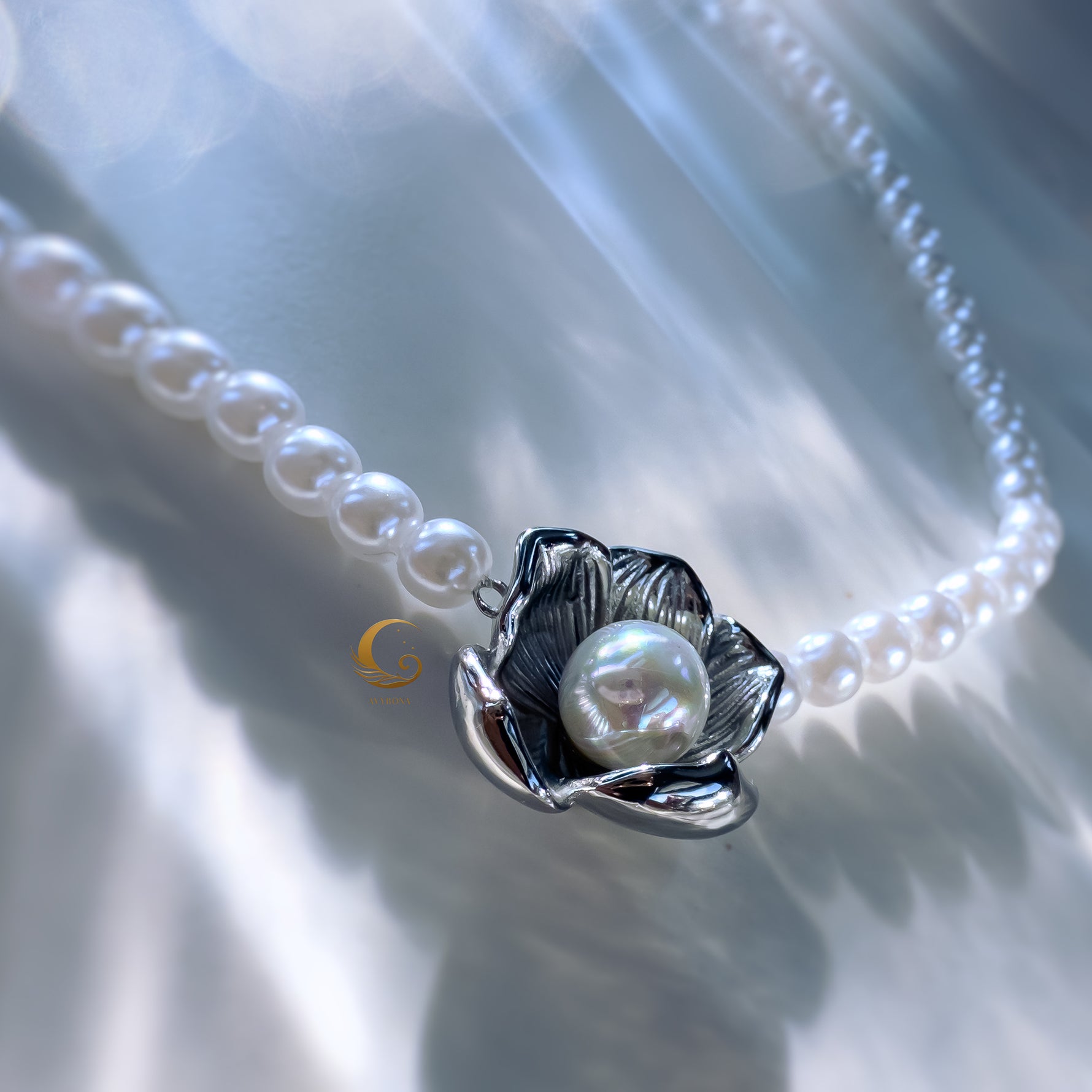 Silver flower pendant pearl necklace in close-up with soft glow
